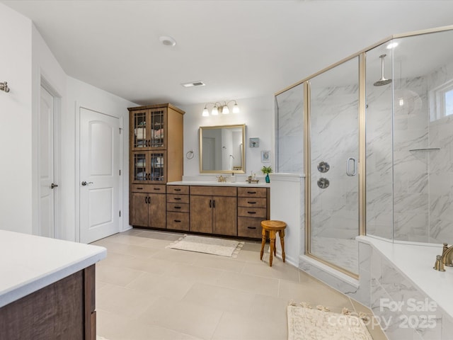 bathroom with visible vents, a marble finish shower, and vanity