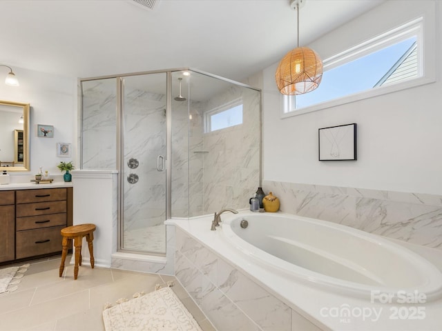 full bath with tile patterned flooring, a marble finish shower, a bath, and vanity