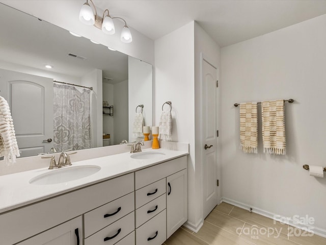 bathroom featuring a closet, visible vents, a sink, and double vanity