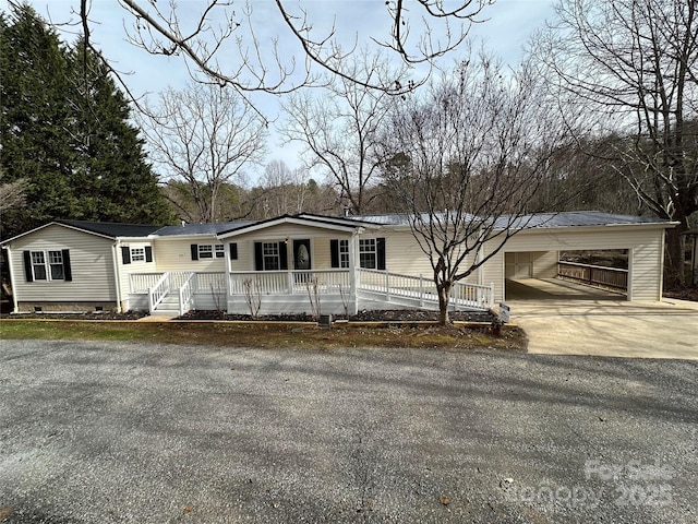 manufactured / mobile home featuring crawl space, an attached carport, a porch, and concrete driveway