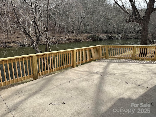 wooden deck with a water view and a view of trees