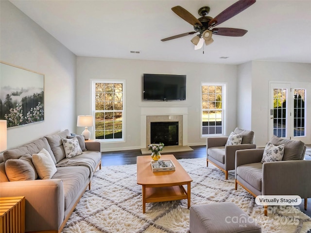 living room featuring a premium fireplace, ceiling fan, and light hardwood / wood-style floors