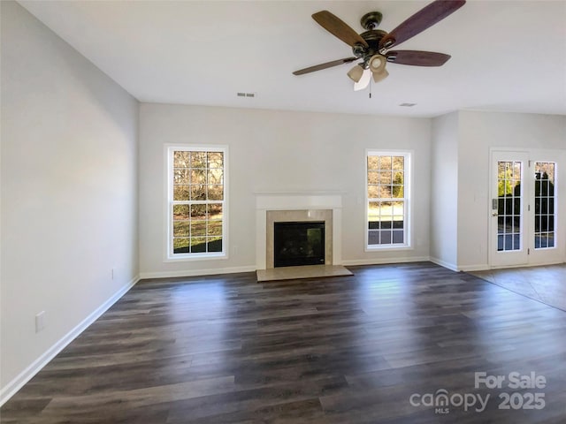 unfurnished living room with ceiling fan, dark hardwood / wood-style flooring, and a premium fireplace