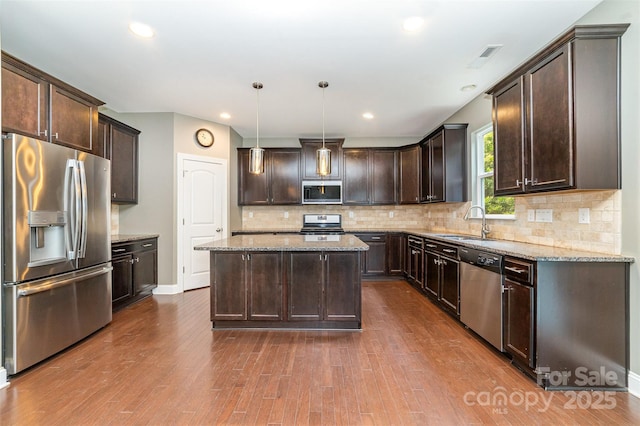 3004 Fallondale Rd, Waxhaw, NC 28173 - kitchen with appliances with stainless steel finishes, dark brown cabinets, a sink, a center island, and light stone countertops