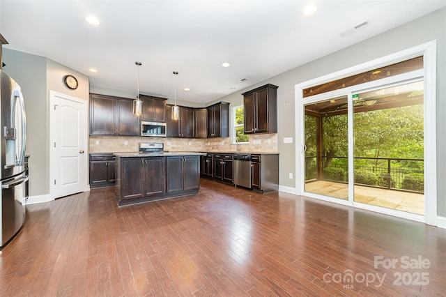 3004 Fallondale Rd, Waxhaw, NC 28173 - kitchen featuring stainless steel appliances, dark brown cabinetry, decorative backsplash, dark wood finished floors, and baseboards