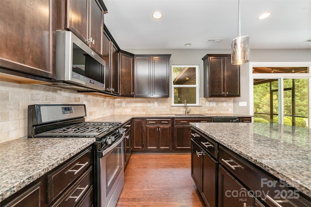 3004 Fallondale Rd, Waxhaw, NC 28173 - kitchen with appliances with stainless steel finishes, a sink, dark brown cabinetry, stone countertops, and recessed lighting