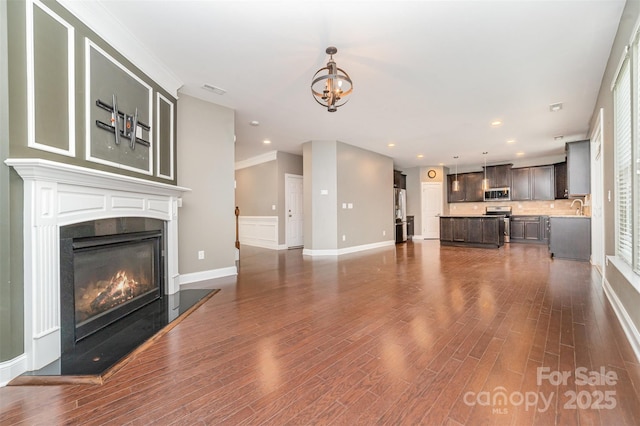 3004 Fallondale Rd, Waxhaw, NC 28173 - unfurnished living room with dark wood-type flooring, a glass covered fireplace, a chandelier, baseboards, and recessed lighting