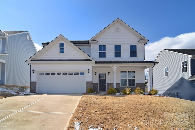 view of front of house featuring stone siding, a porch, and concrete driveway