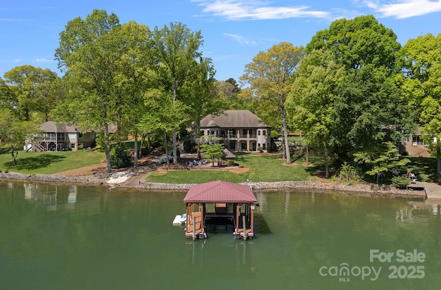 dock area with a lawn, boat lift, and a water view