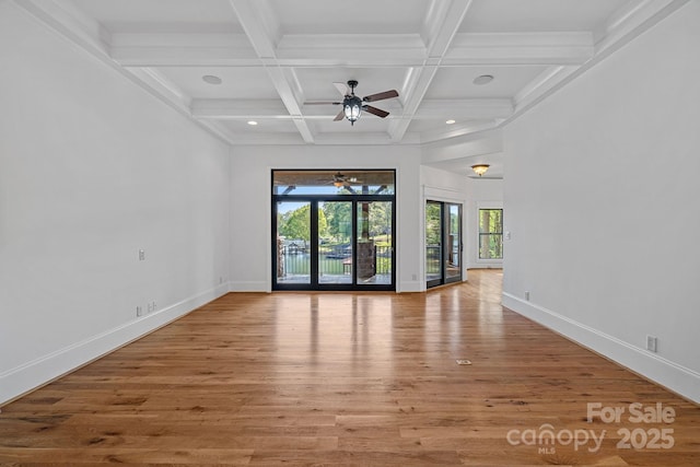 empty room featuring baseboards, wood finished floors, beam ceiling, and ceiling fan