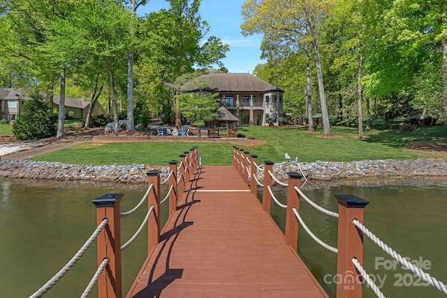 view of dock with a gazebo, a yard, and a water view