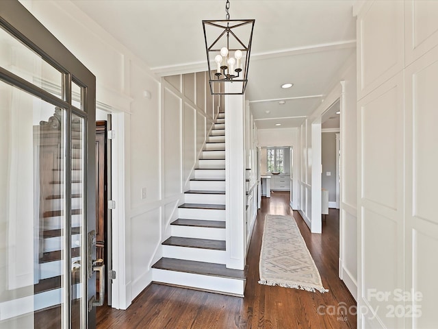 entrance foyer featuring dark wood-type flooring and a notable chandelier