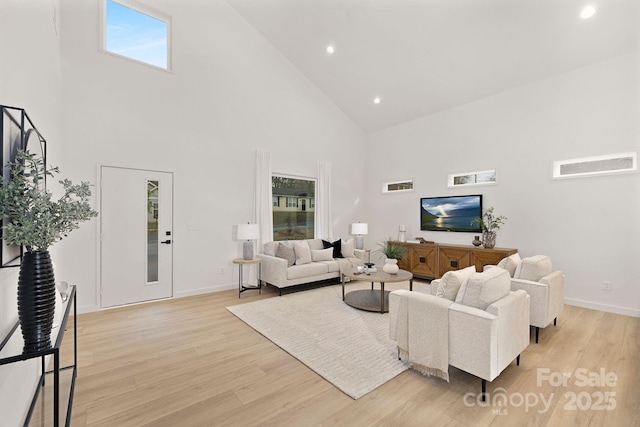 living room featuring high vaulted ceiling and light hardwood / wood-style floors