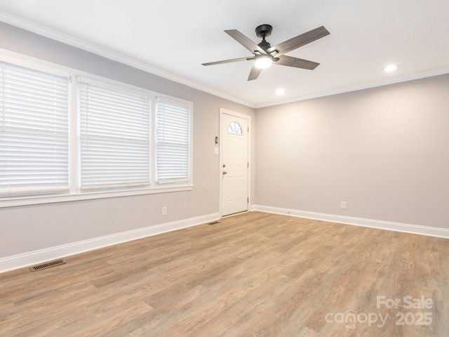 unfurnished room featuring visible vents, baseboards, a ceiling fan, crown molding, and light wood-type flooring