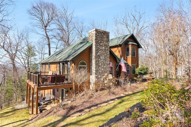 view of side of property featuring a deck and a chimney