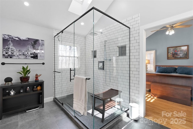 full bath with recessed lighting, a stall shower, tile patterned flooring, ceiling fan, and vaulted ceiling with skylight