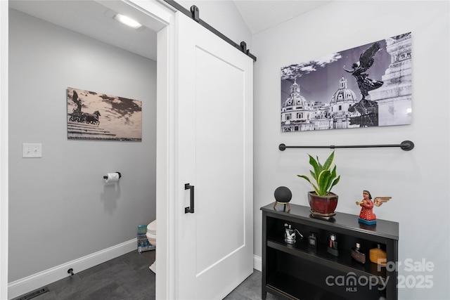 interior space featuring a barn door and baseboards