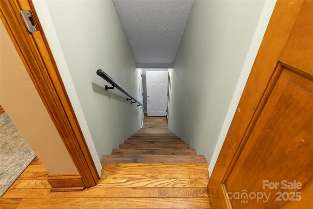 staircase with a textured ceiling