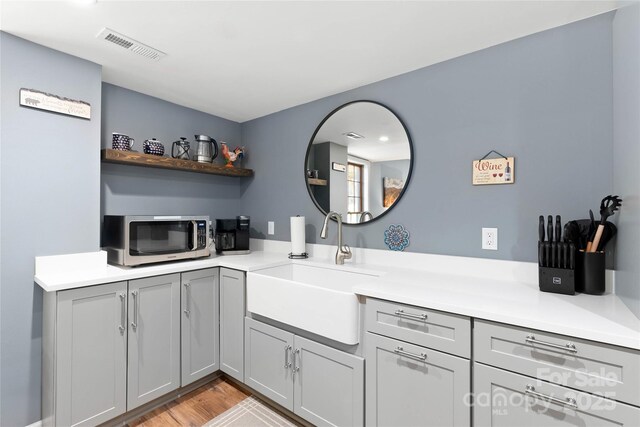 bathroom with visible vents, vanity, and wood finished floors