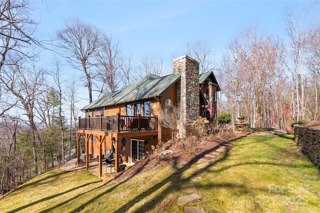 view of home's exterior featuring a chimney, a yard, and a deck