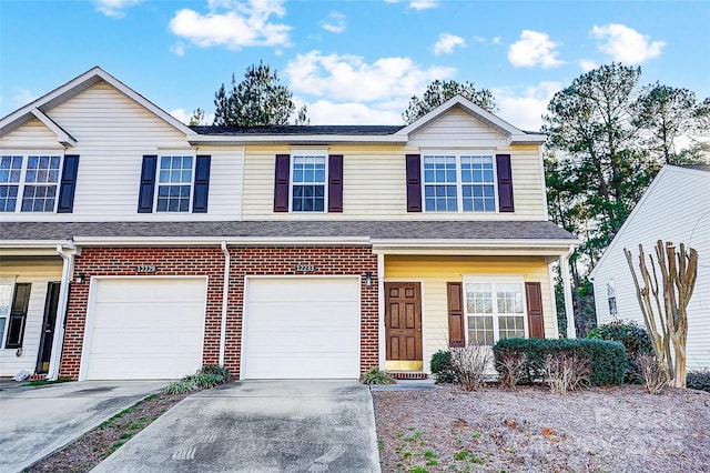 multi unit property featuring a shingled roof, concrete driveway, brick siding, and an attached garage