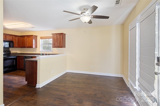 kitchen featuring sink, a textured ceiling, dark wood-type flooring, black appliances, and kitchen peninsula