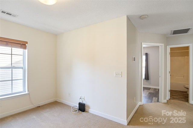 unfurnished room featuring light carpet