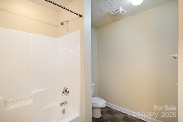 bathroom with toilet, tub / shower combination, a textured ceiling, and tile patterned floors