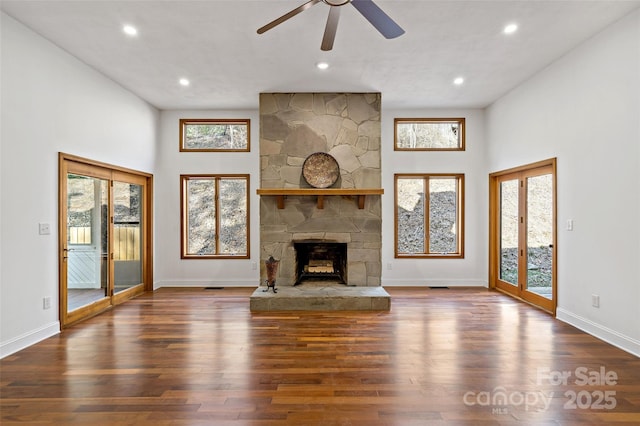 unfurnished living room featuring dark wood finished floors, a fireplace, baseboards, and recessed lighting