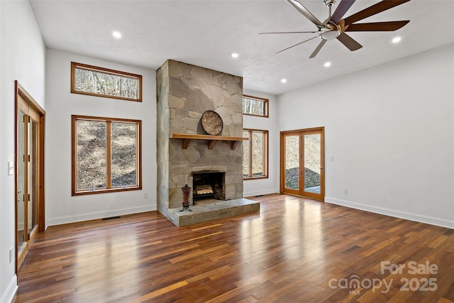 unfurnished living room with recessed lighting, a fireplace, dark wood finished floors, and baseboards