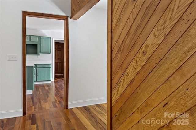 corridor with dark wood-style floors and baseboards