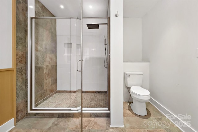 bathroom featuring a stall shower and toilet