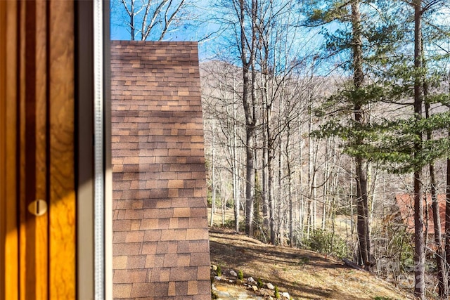 exterior space featuring roof with shingles