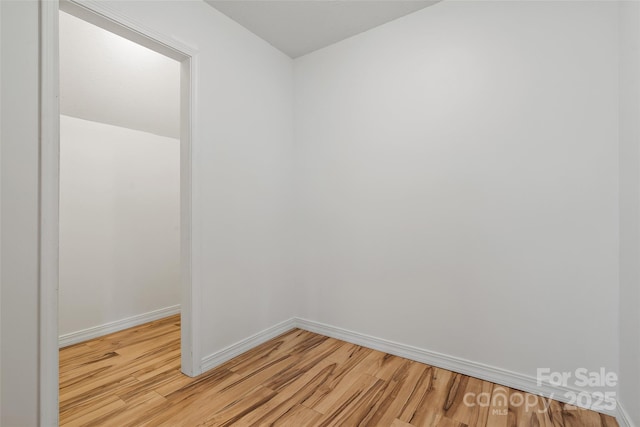 spare room featuring light wood-type flooring and baseboards