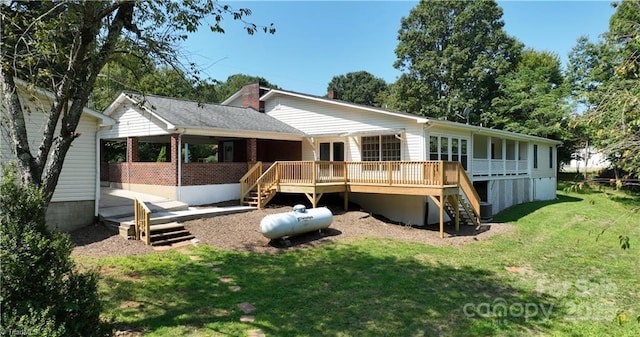 rear view of property with a deck and a lawn