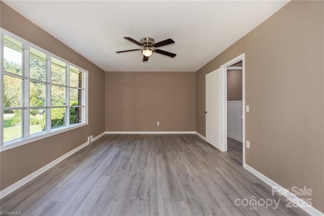 empty room with light wood-type flooring and ceiling fan