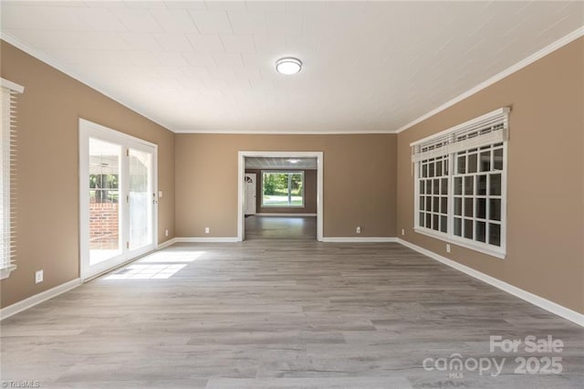 spare room with light hardwood / wood-style flooring and crown molding