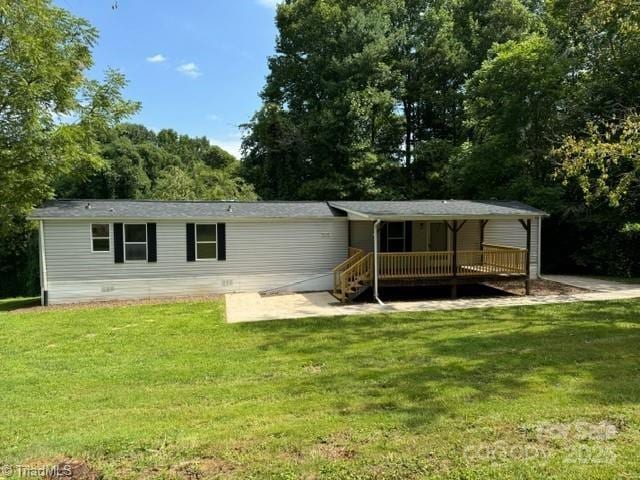 back of property featuring a yard and a deck