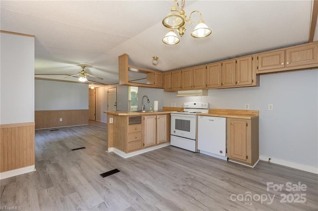 kitchen with white appliances, lofted ceiling, pendant lighting, sink, and kitchen peninsula