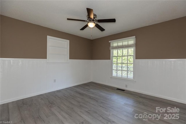 unfurnished room with hardwood / wood-style floors and ceiling fan