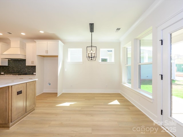 kitchen featuring a chandelier, custom range hood, visible vents, and light wood finished floors