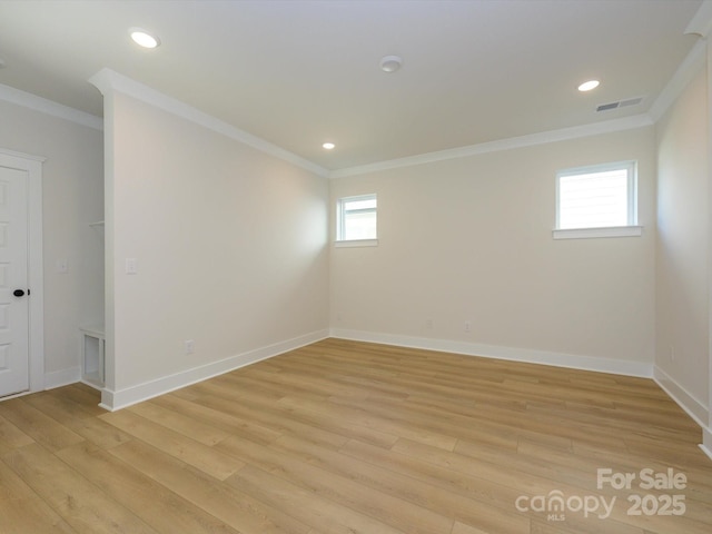 unfurnished room with baseboards, visible vents, light wood-type flooring, and crown molding