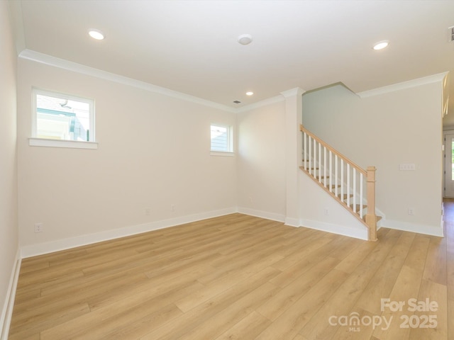 spare room featuring baseboards, light wood-type flooring, ornamental molding, recessed lighting, and stairway
