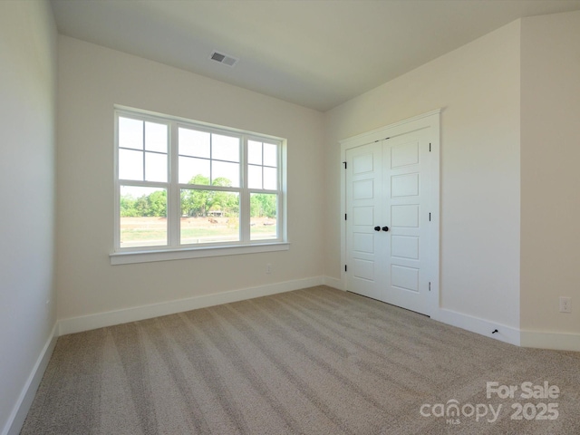 unfurnished bedroom with visible vents, baseboards, and carpet