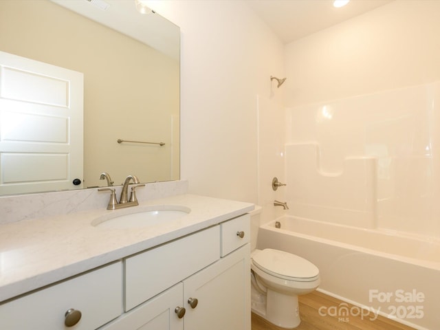 bathroom featuring bathing tub / shower combination, toilet, vanity, and wood finished floors