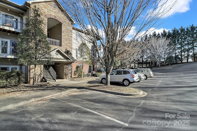 view of road featuring stairway, curbs, and sidewalks