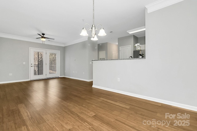 unfurnished room with dark wood-style floors, ornamental molding, ceiling fan with notable chandelier, and baseboards