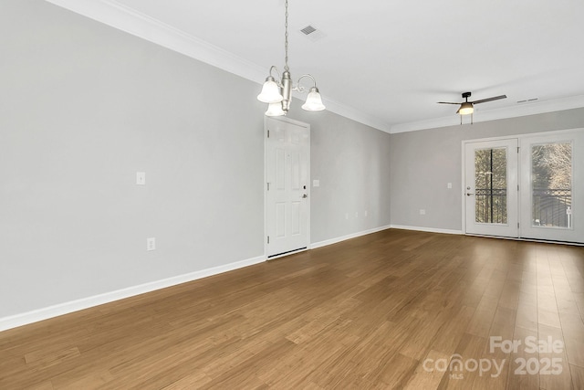 unfurnished room featuring crown molding, baseboards, and wood finished floors