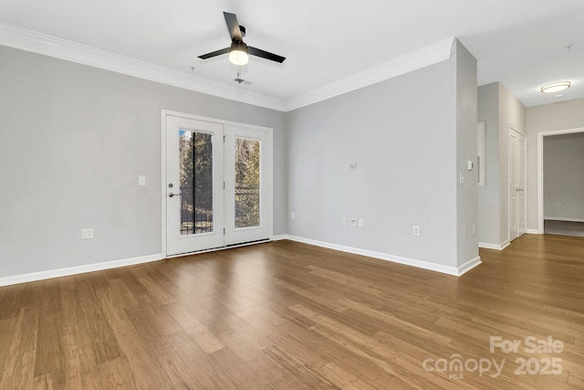 spare room featuring baseboards, crown molding, a ceiling fan, and wood finished floors