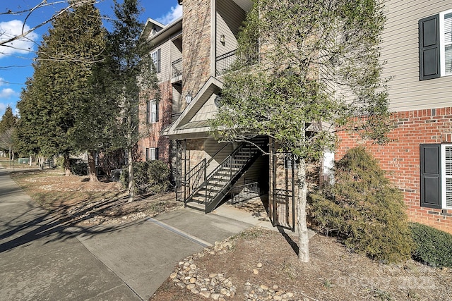 exterior space featuring stairway and brick siding